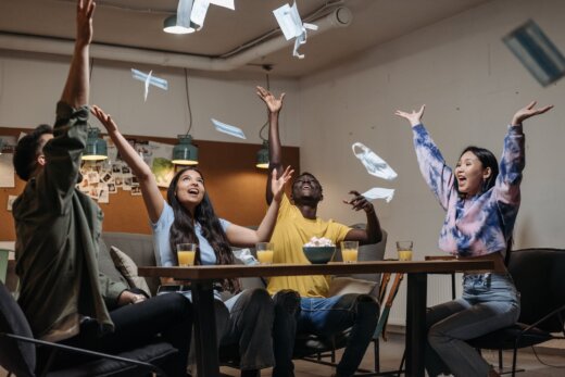 group of people sitting throwing their face mask in the air